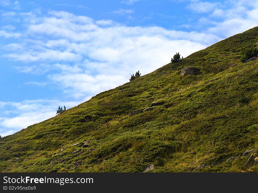 Steep mountain meadow with blue sky. Steep mountain meadow with blue sky