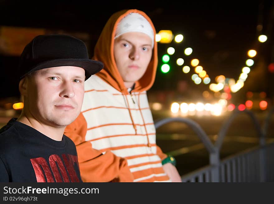 Fashionable young men posing outdoors in the city lights. Fashionable young men posing outdoors in the city lights