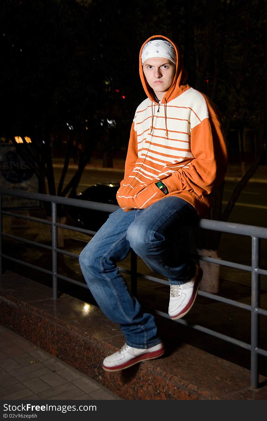 Displeased young punk slanging on the corner at night. Displeased young punk slanging on the corner at night