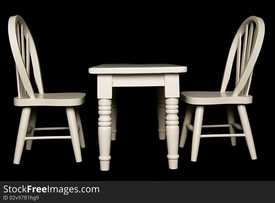 Table and chairs isolated on black background