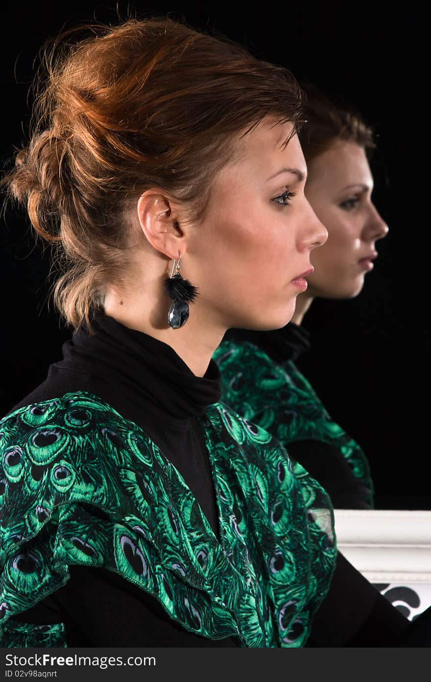 Profile of a young woman against the backdrop of mirror