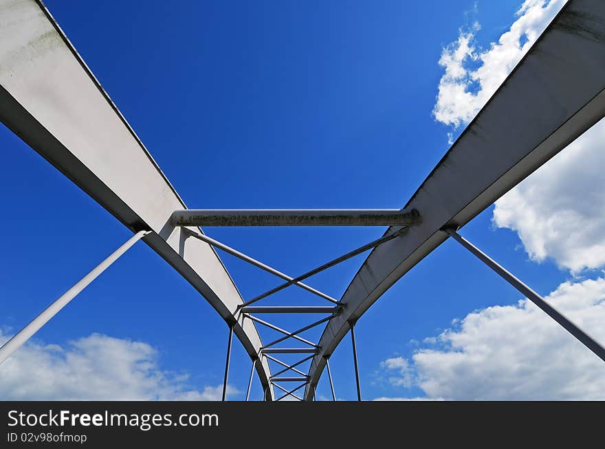 Elements of modern tied arch bridge on picturesque cloudy sky. Elements of modern tied arch bridge on picturesque cloudy sky