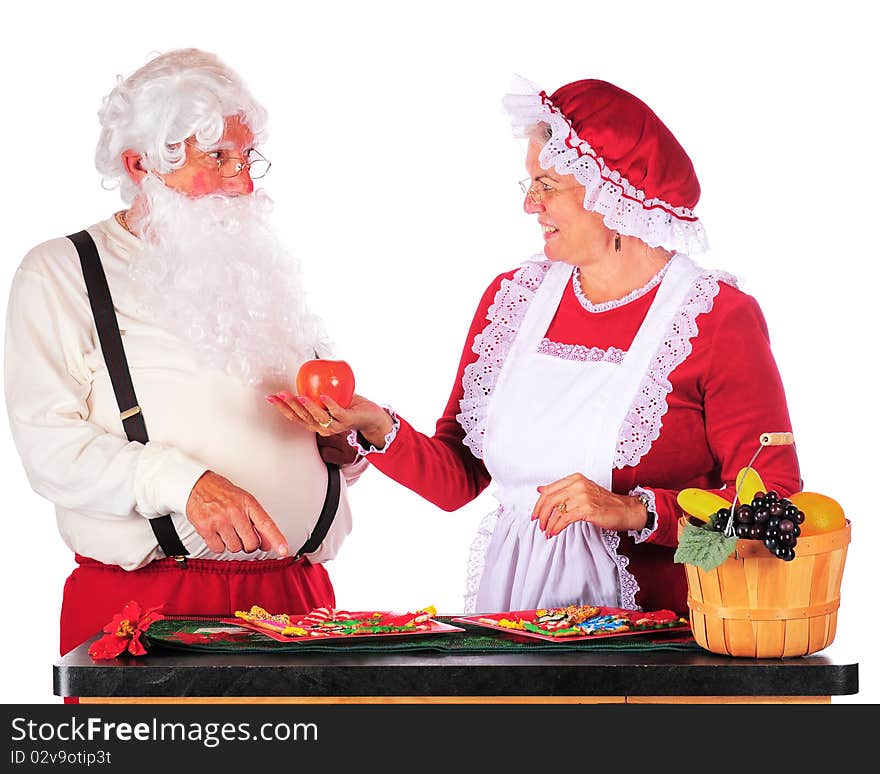 Santa want a cookie, while Mrs. Claus tries to persaude him to eat healthy instead. Isolated on white. Santa want a cookie, while Mrs. Claus tries to persaude him to eat healthy instead. Isolated on white.