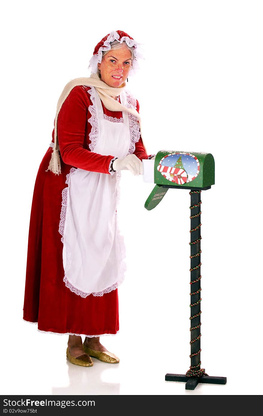 Mrs. Claus collecting Santa's mail from a Christmas decorated rural mailbox.  Isolated on white.