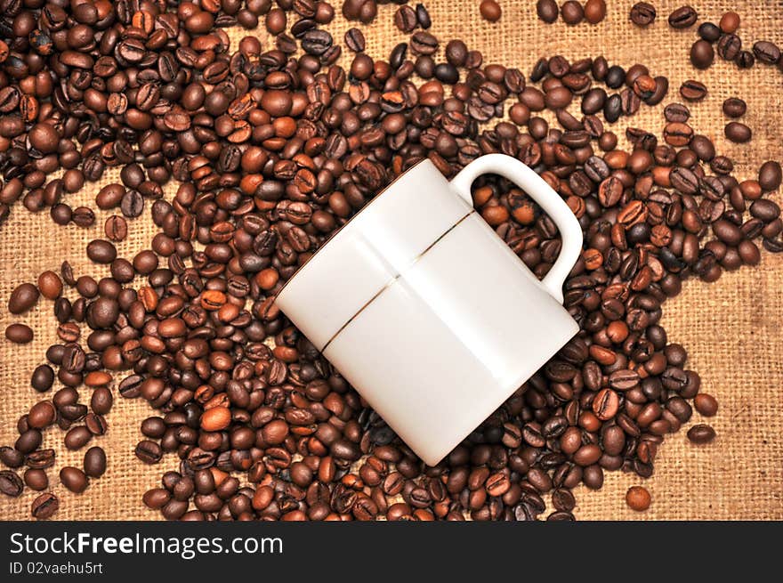 Cup of coffee and grain on a background a rough matter. Cup of coffee and grain on a background a rough matter