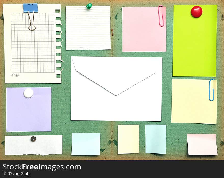 Bulletin board with notes, business cards and envelope