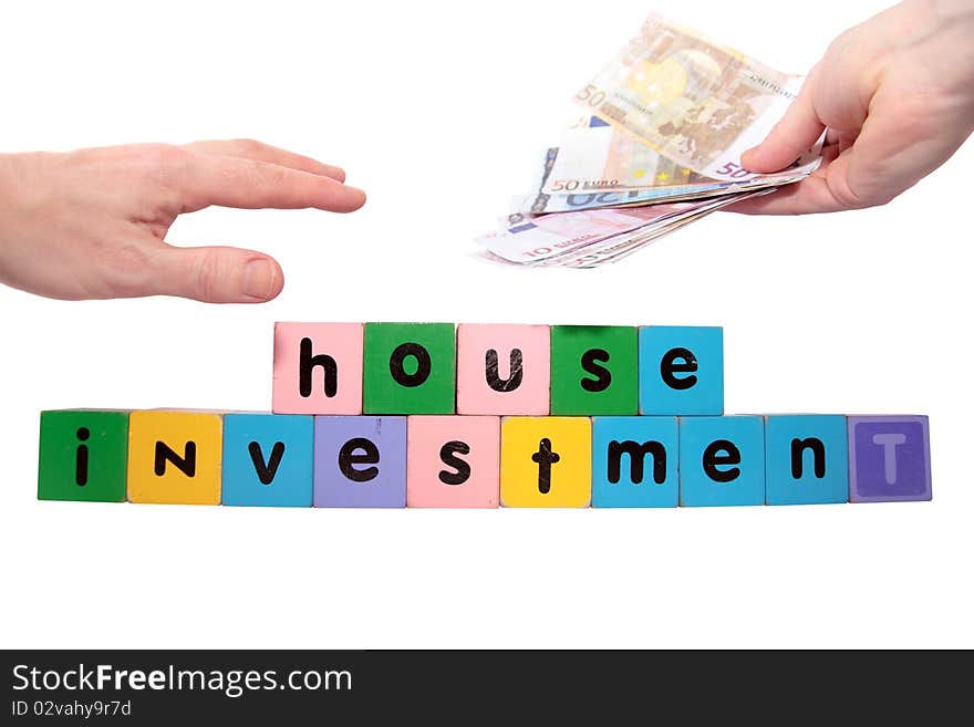 Toy letters that spell house investment with cash in hands against a white background with clipping path. Toy letters that spell house investment with cash in hands against a white background with clipping path