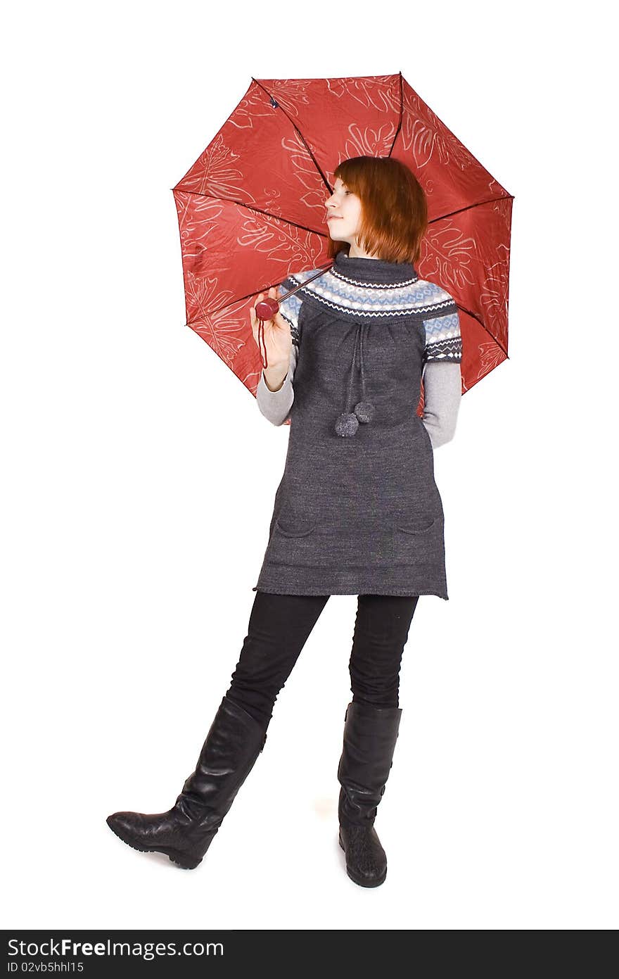 Young beautiful girl in knit dress with red umbrella standing isolated on white, looking left