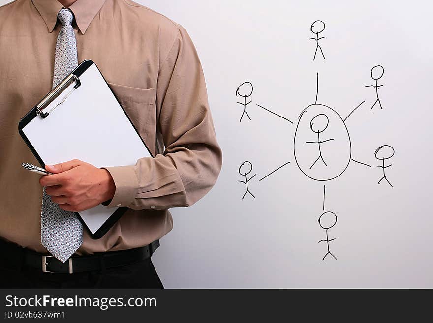 Man in a shirt and a tie standing next to a drawing of a hierarchy. Man in a shirt and a tie standing next to a drawing of a hierarchy.