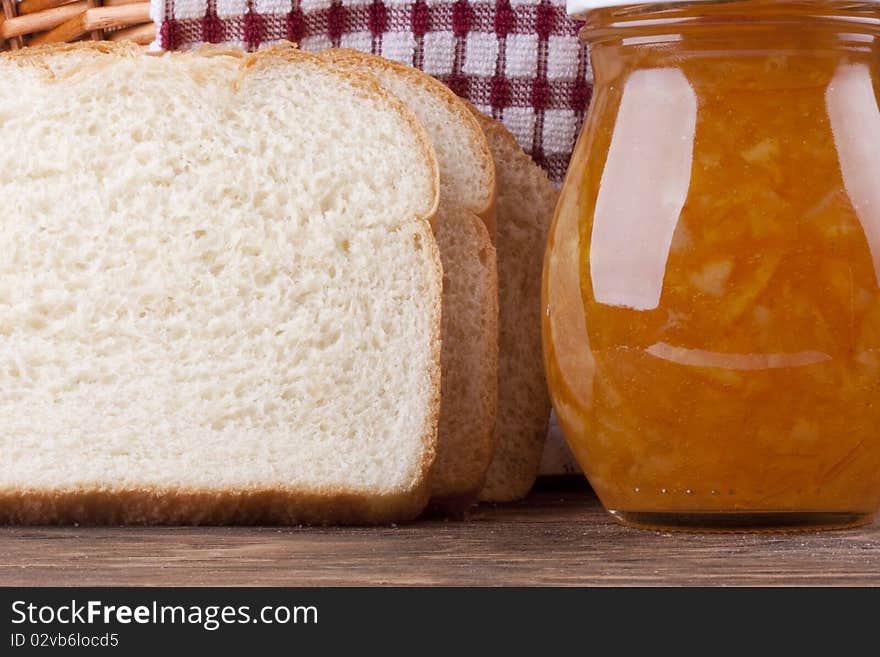 Yellow jam in bank and a white bread for a sweet sandwich. Yellow jam in bank and a white bread for a sweet sandwich.