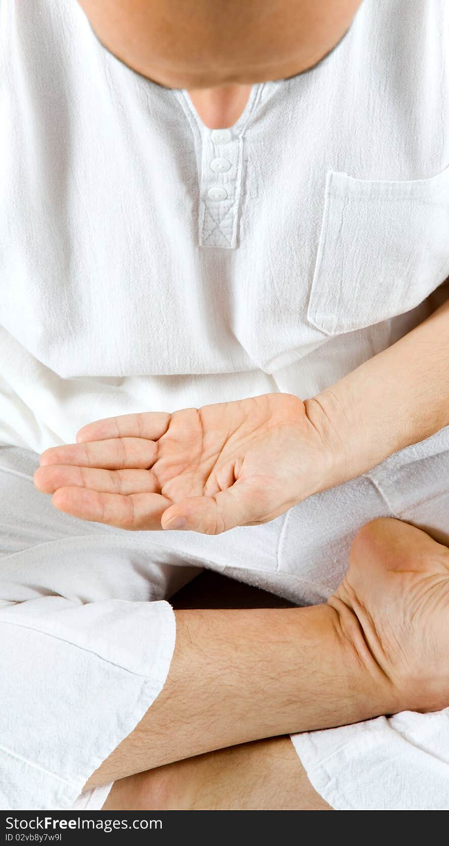 Hand of a man sitting in meditation position, palm open, looking down. Hand of a man sitting in meditation position, palm open, looking down