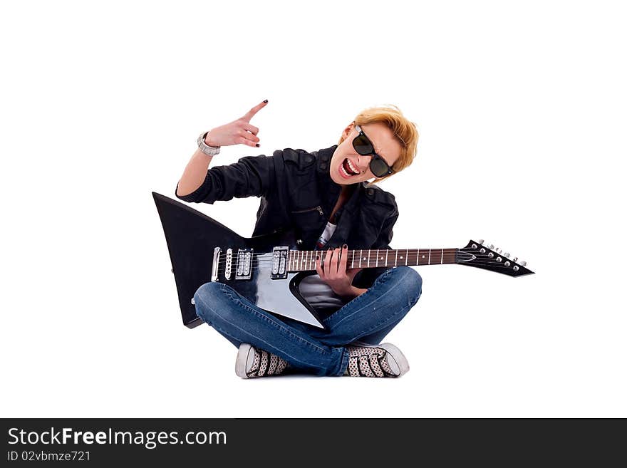 Passionate rock girl playing an electric guitar seated and making a rock gesture. Passionate rock girl playing an electric guitar seated and making a rock gesture