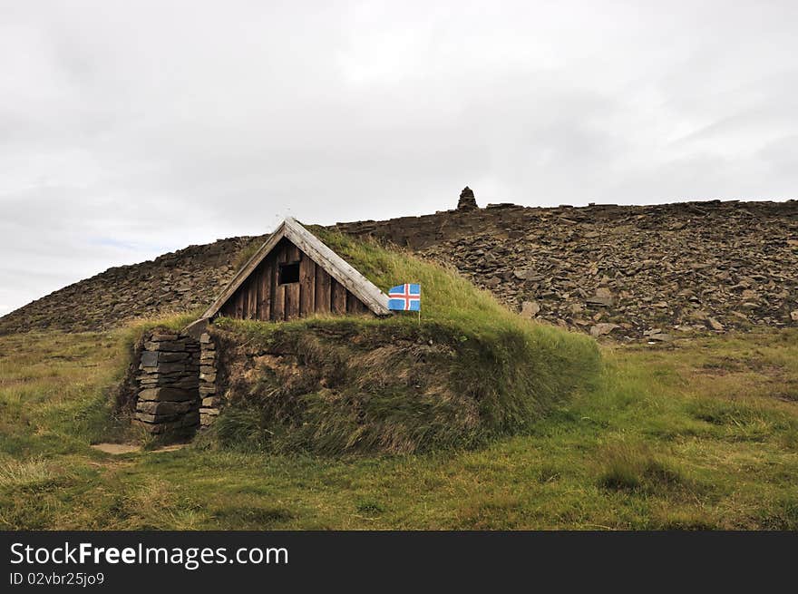 Traditional turf house with flag in Iceland. Traditional turf house with flag in Iceland.