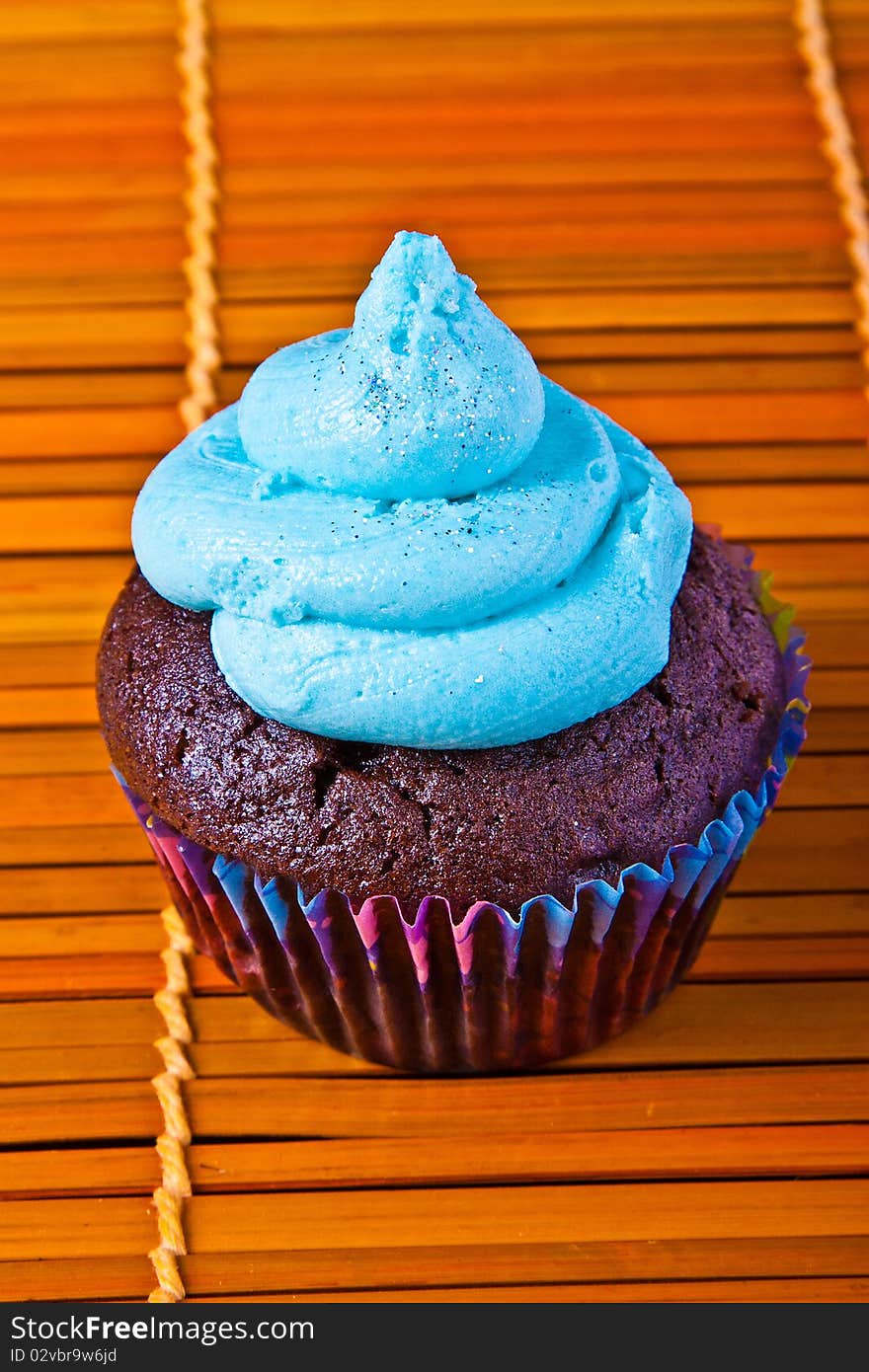 Blue vanilla cupcake over a bamboo table place mats