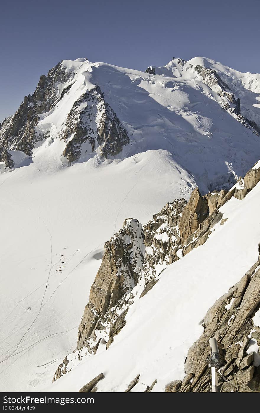 From the summit of l'Aiguille du Midi (3,842 m), the views of the Alps are spectacular. Views of Mont Blanc, from L'Aiguille du Midi.On the side of the mountain, you can see the tents, planted by the mountaineers, for the night, before climbing to the summit of Mont Blanc. From the summit of l'Aiguille du Midi (3,842 m), the views of the Alps are spectacular. Views of Mont Blanc, from L'Aiguille du Midi.On the side of the mountain, you can see the tents, planted by the mountaineers, for the night, before climbing to the summit of Mont Blanc.