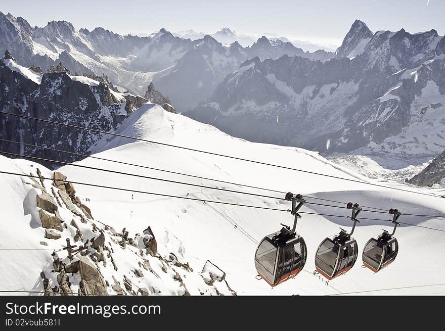 From the summit of l'Aiguille du Midi (3,842 m), the views of the Alps are spectacular. In this picture, you can see the panoramic funicular leading to a peak in Italy. From the summit of l'Aiguille du Midi (3,842 m), the views of the Alps are spectacular. In this picture, you can see the panoramic funicular leading to a peak in Italy