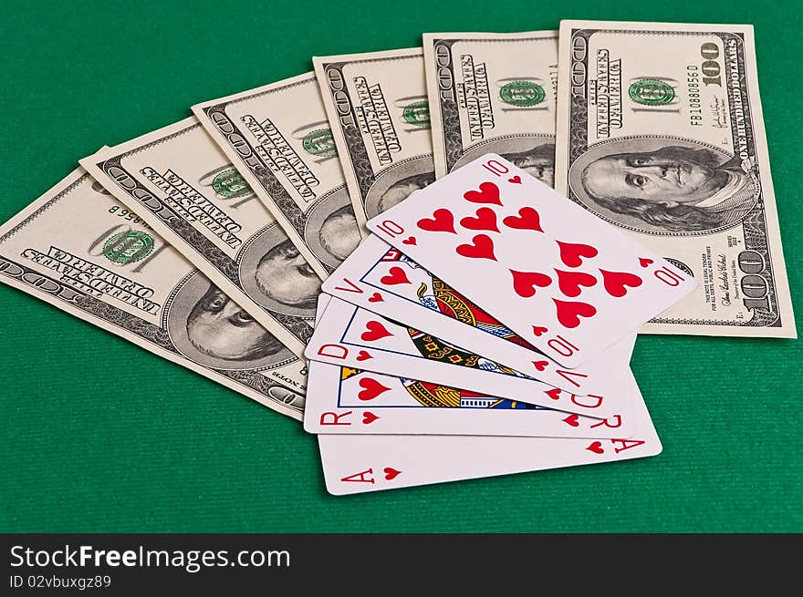 Poker cards showing royal flush and dollars on green cloth