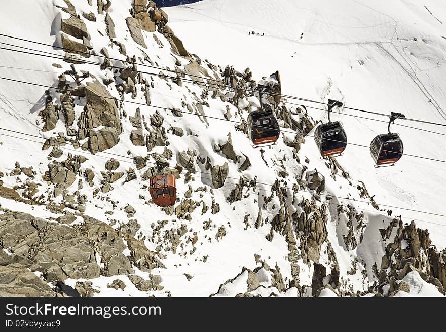 From the summit of l'Aiguille du Midi (3,842 m), the views of the Alps are spectacular. In this picture, you can see the old cable car nowadays is no longer used, along with new leads to a peak in Italy. From the summit of l'Aiguille du Midi (3,842 m), the views of the Alps are spectacular. In this picture, you can see the old cable car nowadays is no longer used, along with new leads to a peak in Italy