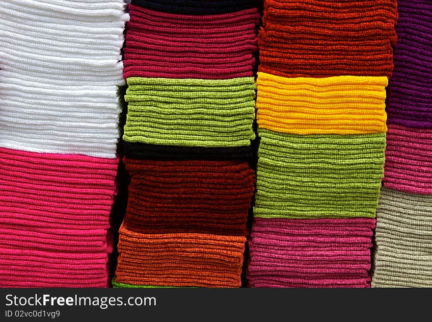 Towels of many colors are stacked atop each other, on display at the Otavalo MarketPlace in Ecuador, the largest indigenious marketplace in the world. Towels fill the frame and can be used for a horizontal design background. Towels of many colors are stacked atop each other, on display at the Otavalo MarketPlace in Ecuador, the largest indigenious marketplace in the world. Towels fill the frame and can be used for a horizontal design background.