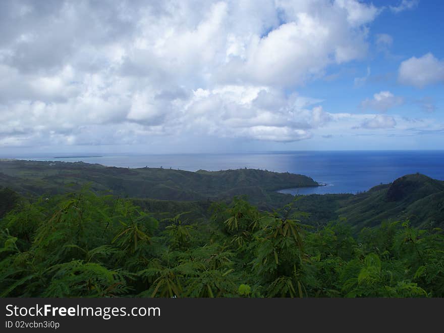 Taken in Guam looking down at the ocean with a lush portion of a tropical rain forest in the foreground. Taken in Guam looking down at the ocean with a lush portion of a tropical rain forest in the foreground.