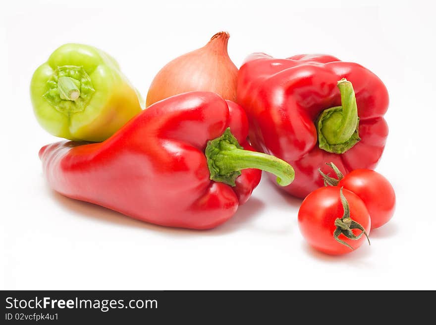 Fresh ripe red and green peppers with onion and cherry-tomatoes isolated on white background. Fresh ripe red and green peppers with onion and cherry-tomatoes isolated on white background