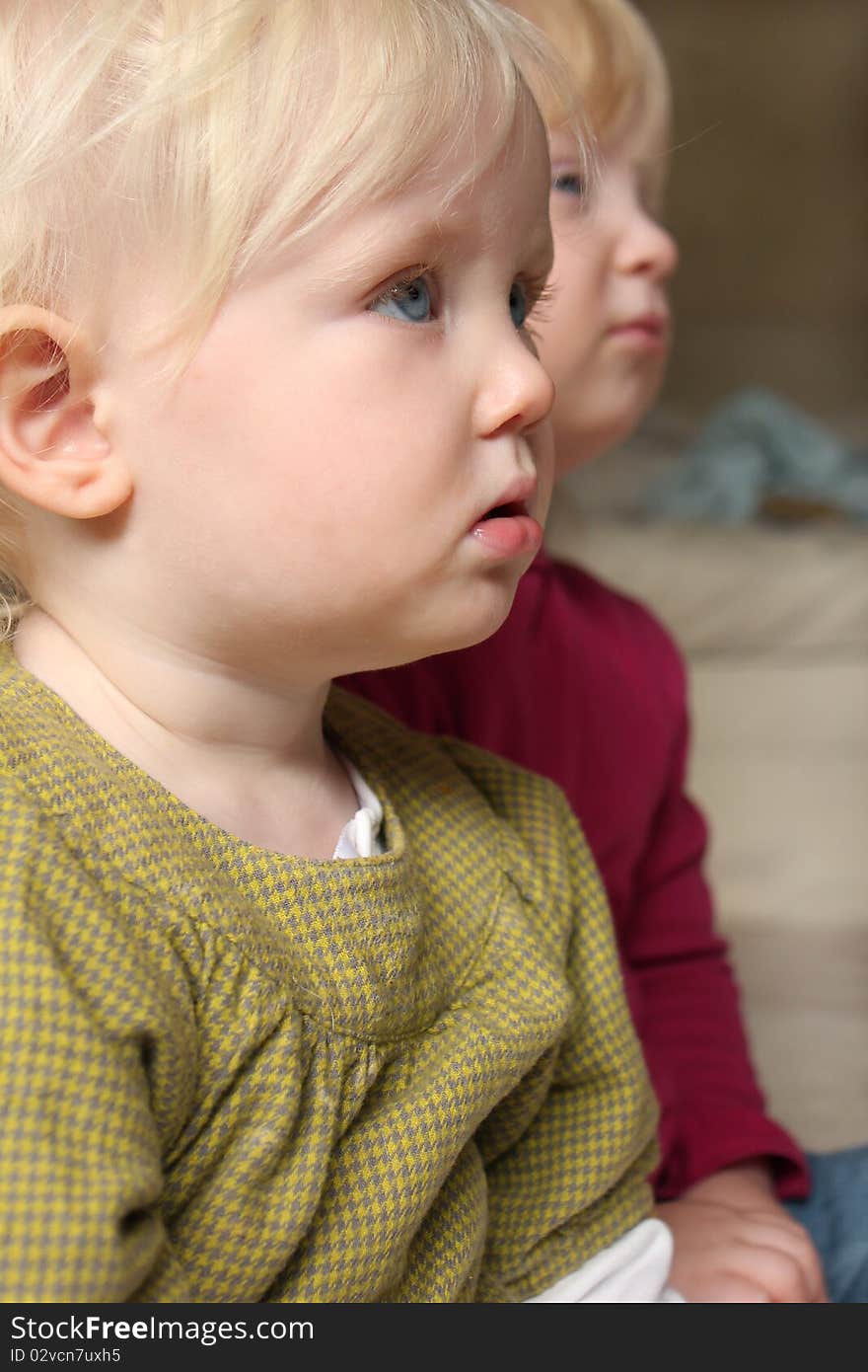 Sisters watching television together close up. Sisters watching television together close up