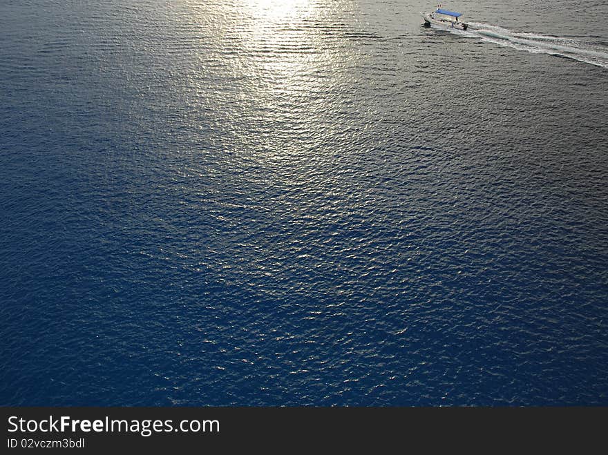 Diving boat returning home in the afternoon as the sun begins to set across the water. Diving boat returning home in the afternoon as the sun begins to set across the water