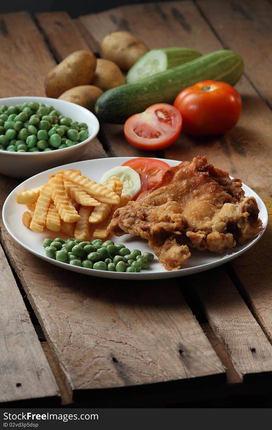 A plate of chicken chop with ingredient background. A plate of chicken chop with ingredient background