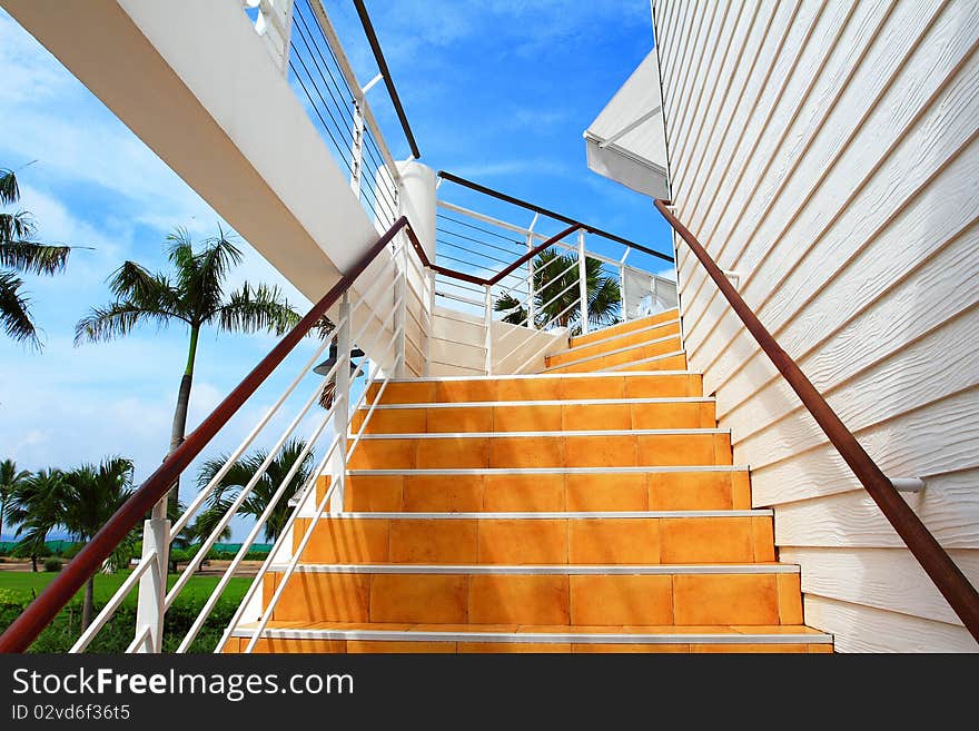 Orange staircase and white wooden wall