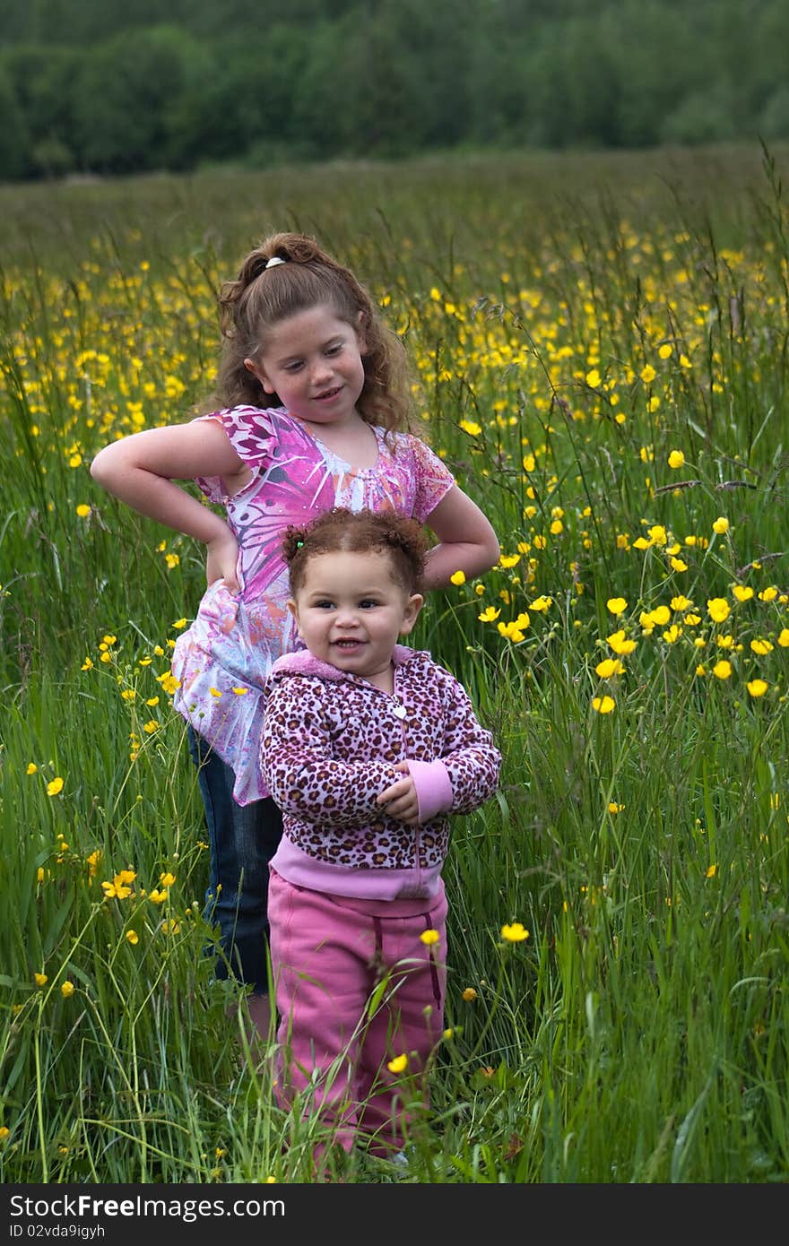 Two young girls playing around in a buttercup field. Two young girls playing around in a buttercup field