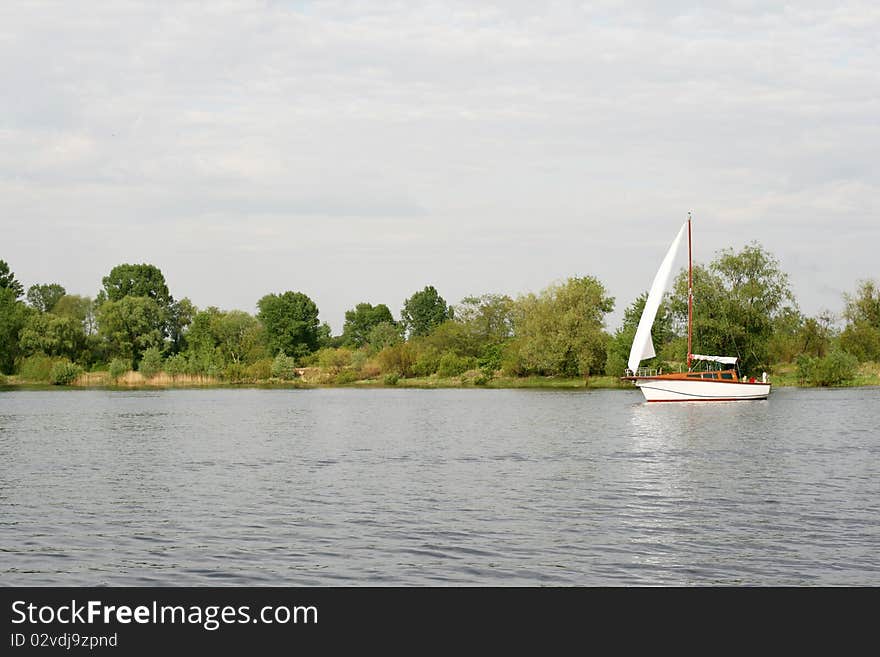 White yacht sailing a river