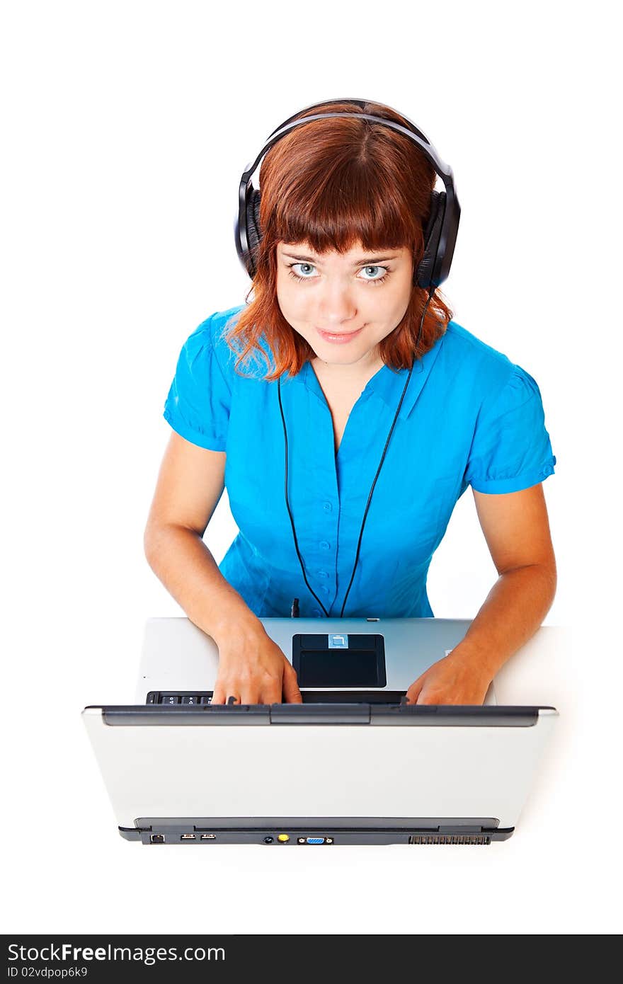 Red-haired teen-girl listen to music in headphones with laptop. Isolated on white background. Red-haired teen-girl listen to music in headphones with laptop. Isolated on white background