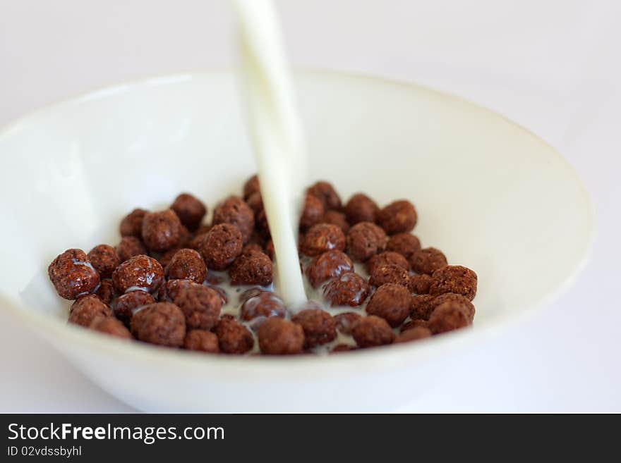 Milk pouring on corn flakes in a bowl. Milk pouring on corn flakes in a bowl