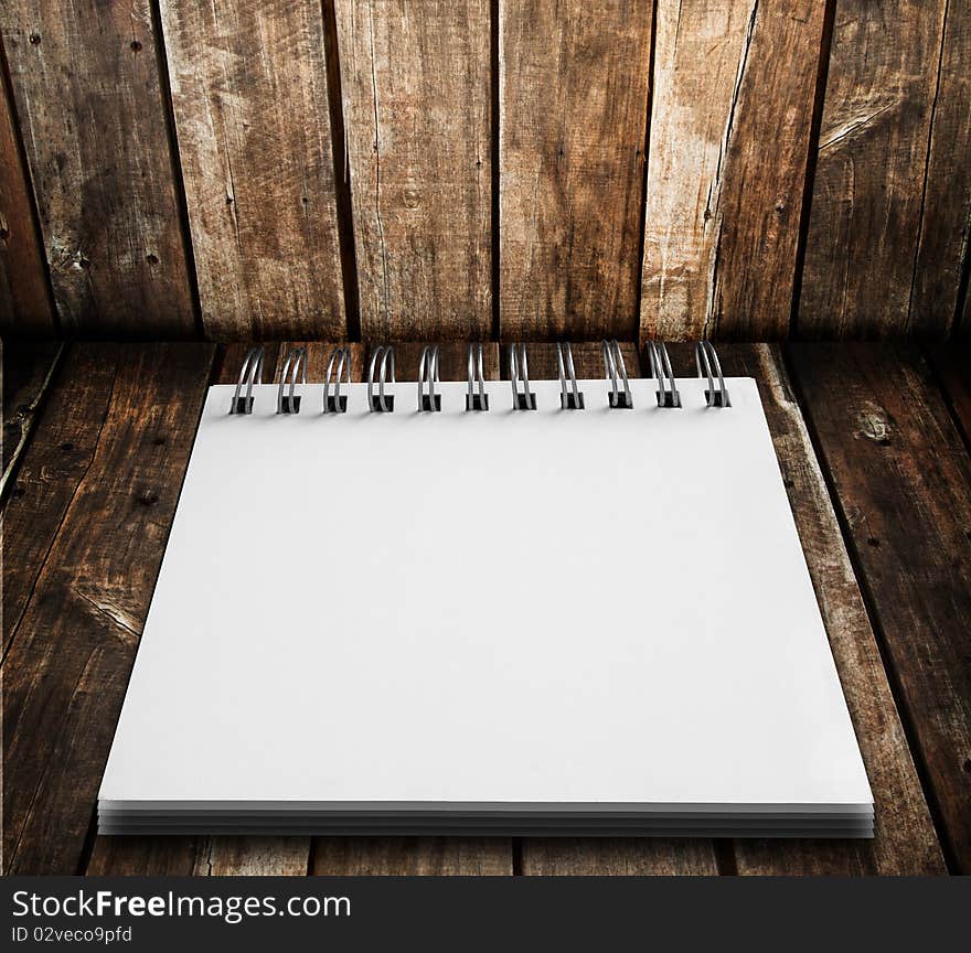 White notebook on wood floor