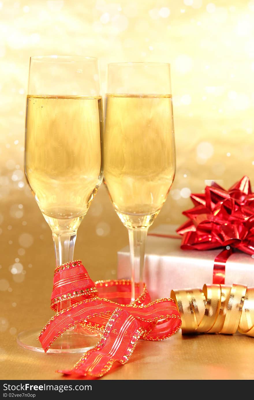 Studio photo of champagne glasses and golden and red decoration on background. Studio photo of champagne glasses and golden and red decoration on background