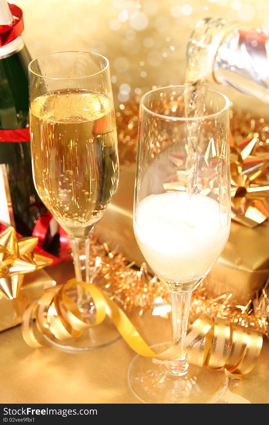 Studio photo of champagne glasses and golden and red decoration on background. Studio photo of champagne glasses and golden and red decoration on background