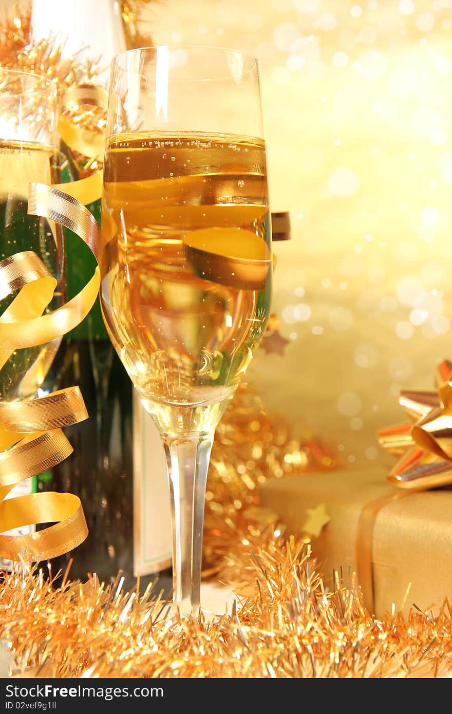 Studio photo of champagne glasses with bottle and golden decoration on background. Studio photo of champagne glasses with bottle and golden decoration on background