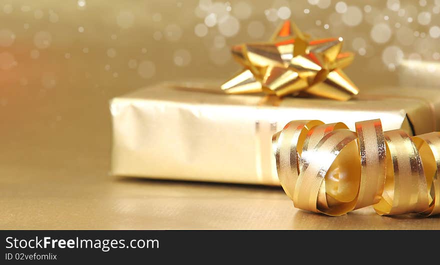 Studio photo of gold gift with decoration. Studio photo of gold gift with decoration