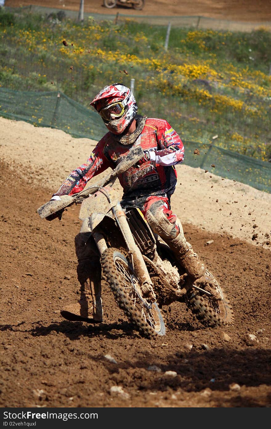 View of a motorcross dirtbike on the dirt performing a turn. View of a motorcross dirtbike on the dirt performing a turn.