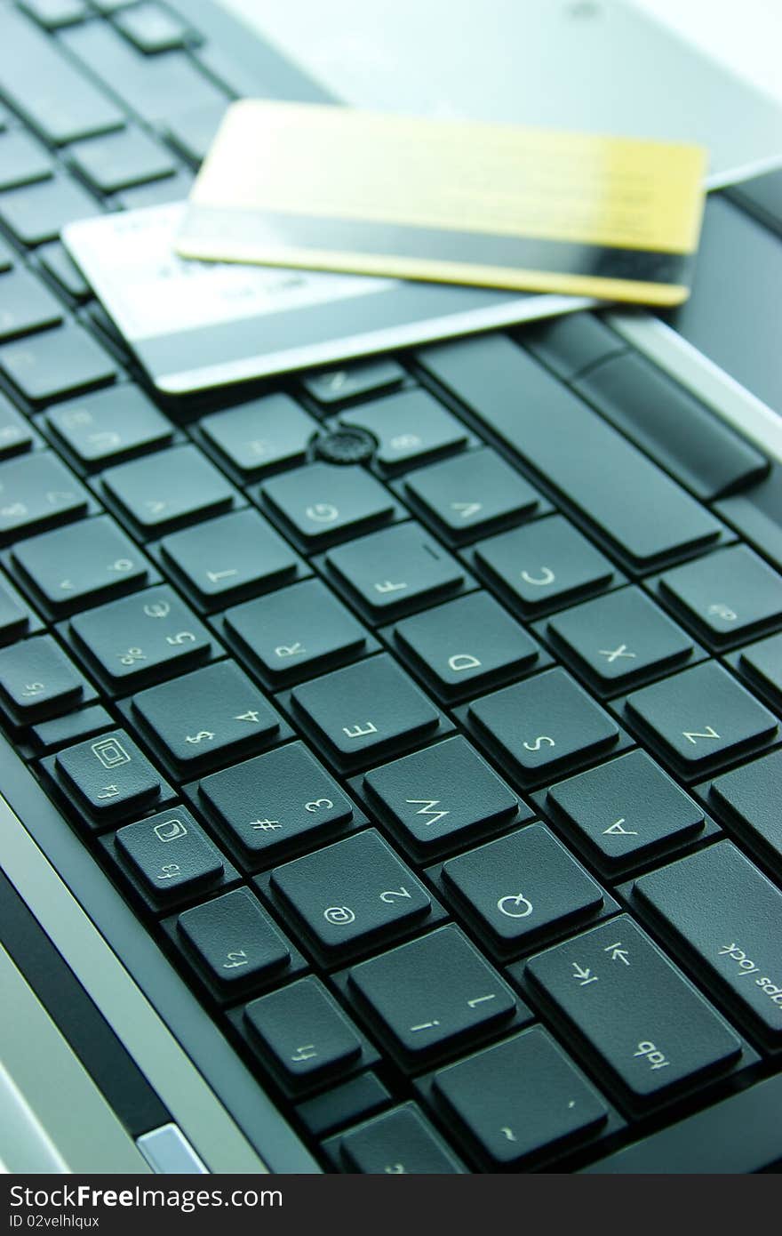 Laptop keyboard with gold and silver credit cards. Laptop keyboard with gold and silver credit cards