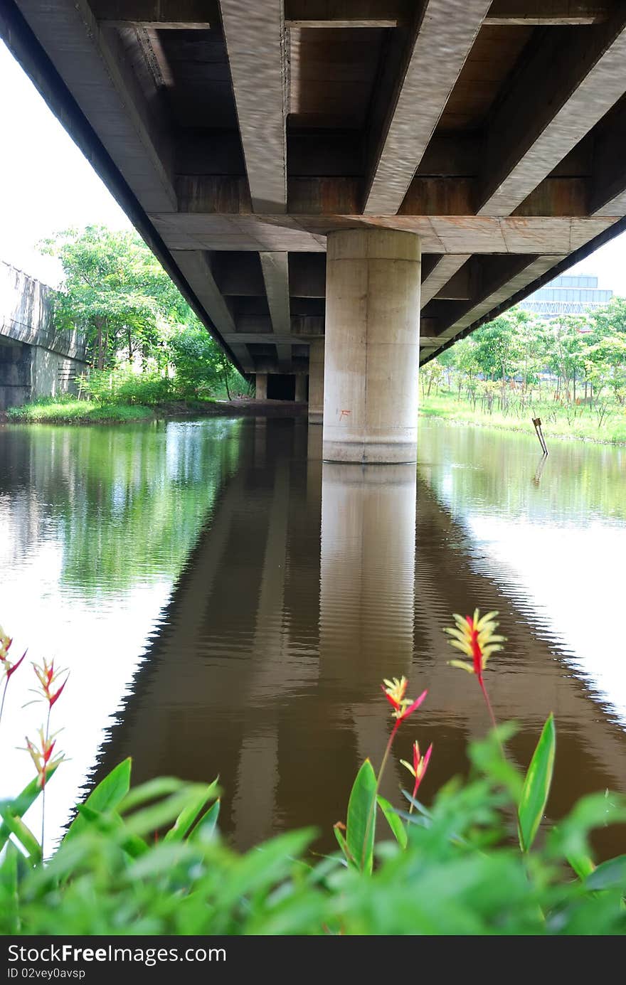 Pillar under the suspension bridge with water reflex