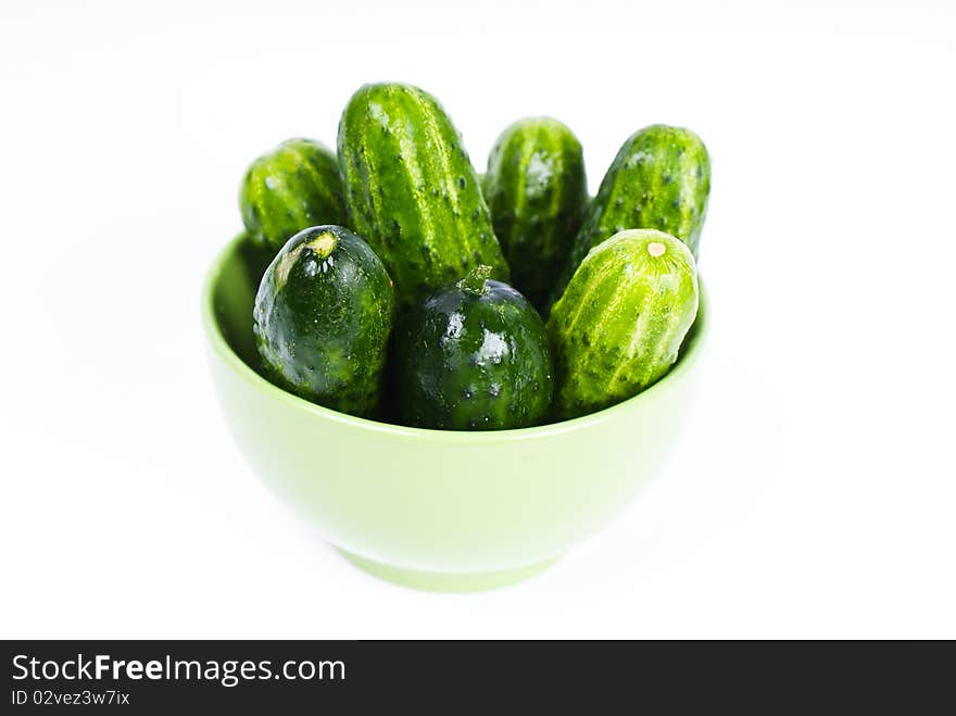 wet cucumbers in green bowl