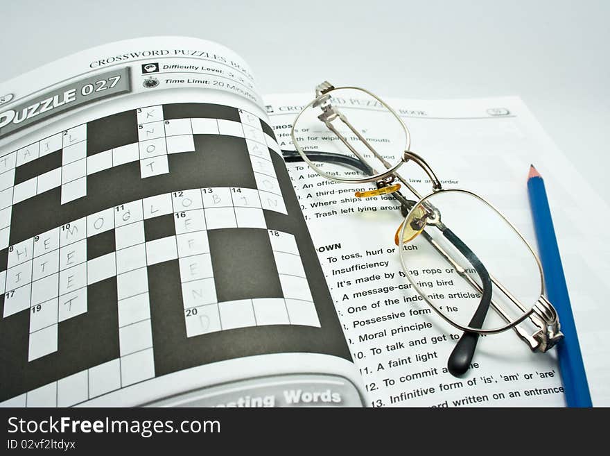 Pen and eyeglass on crossword book