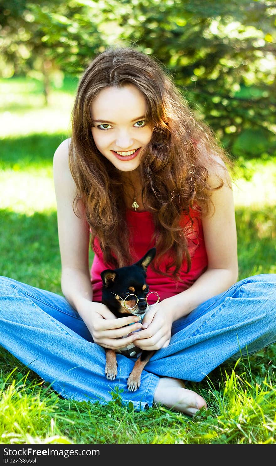 Girl lying on the grass next to a Dog