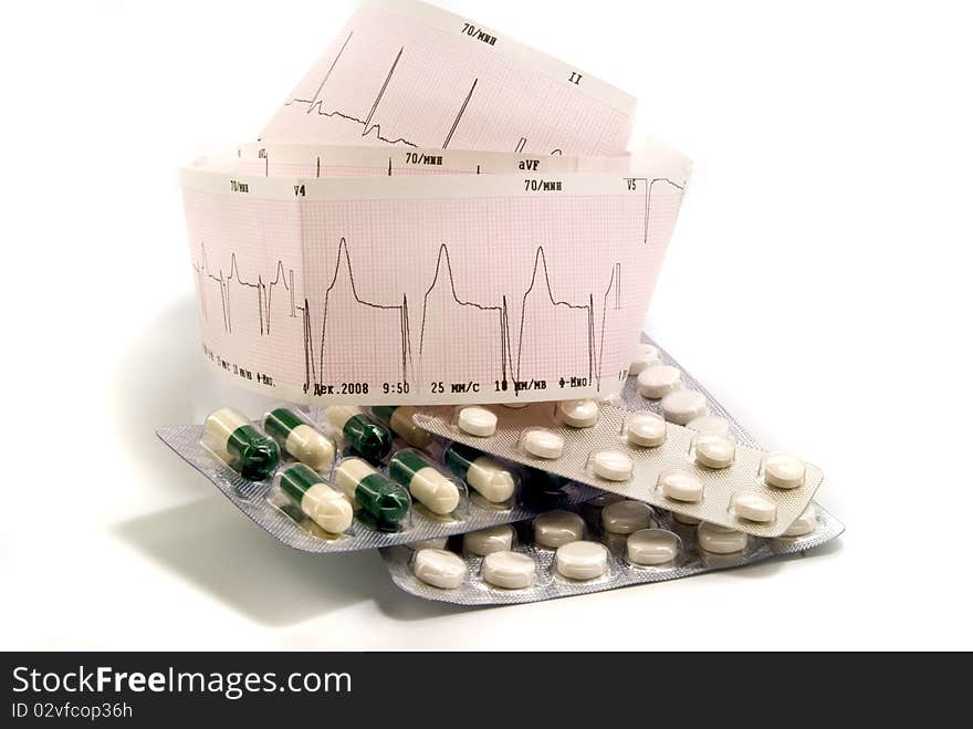 Cardiogram and pills against white background