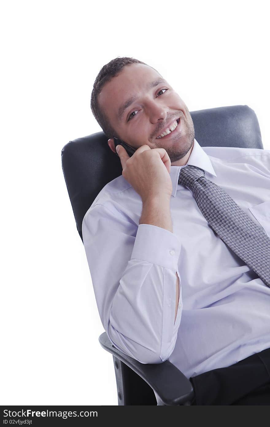 Successful businessman in his chair, talking on mobile phone and smiling, isolated on white. Successful businessman in his chair, talking on mobile phone and smiling, isolated on white