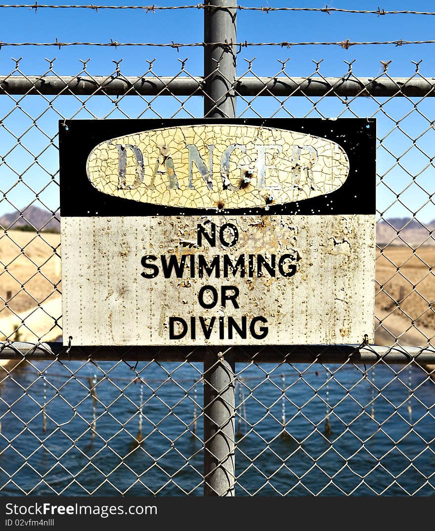 No swimming or diving sign in front of a canal. No swimming or diving sign in front of a canal