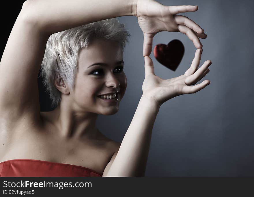 Beautiful model dressed as fashion fairy with heart on black background