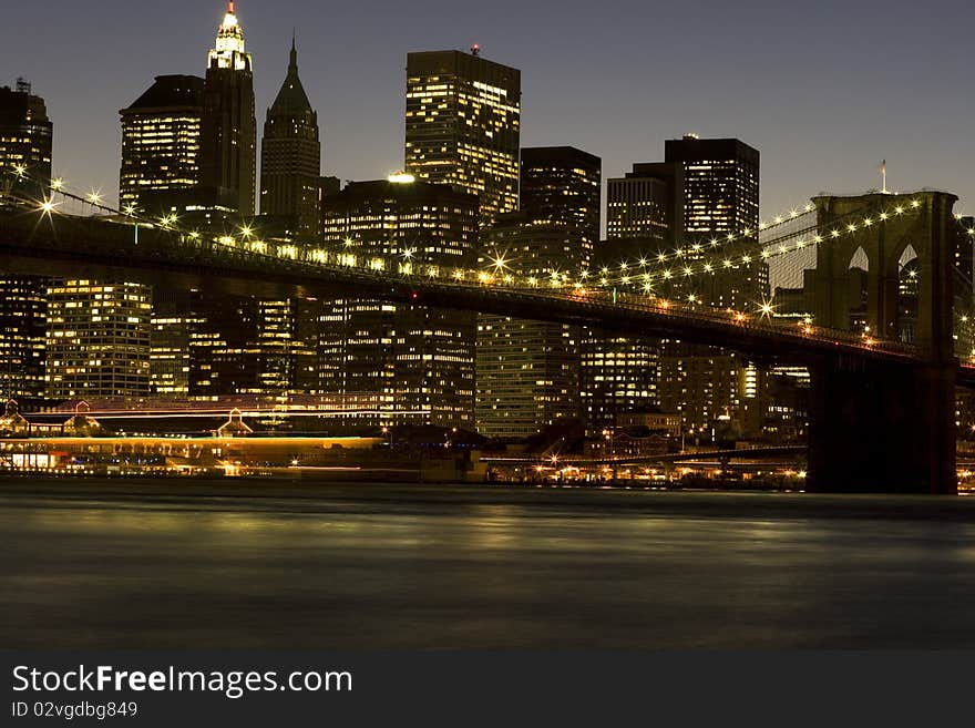 Downtown New York City Skyline and Brooklyn Bridge at dusk. Time Exposure with blurred motion. Downtown New York City Skyline and Brooklyn Bridge at dusk. Time Exposure with blurred motion.