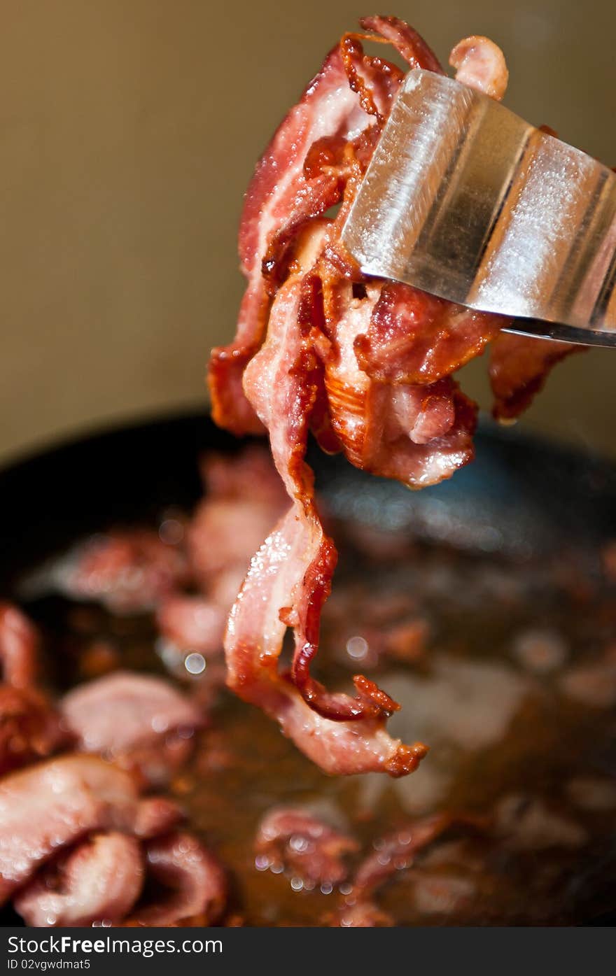 Freshly fried crispy pork bacon in an iron pan. Freshly fried crispy pork bacon in an iron pan.